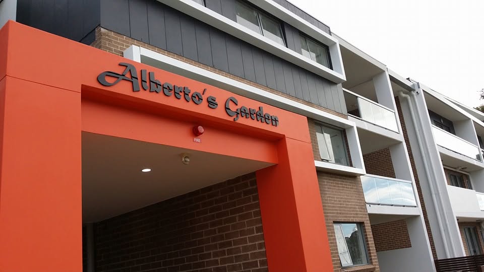 Entry letters for Alberto's Garden apartments over an orange portal
